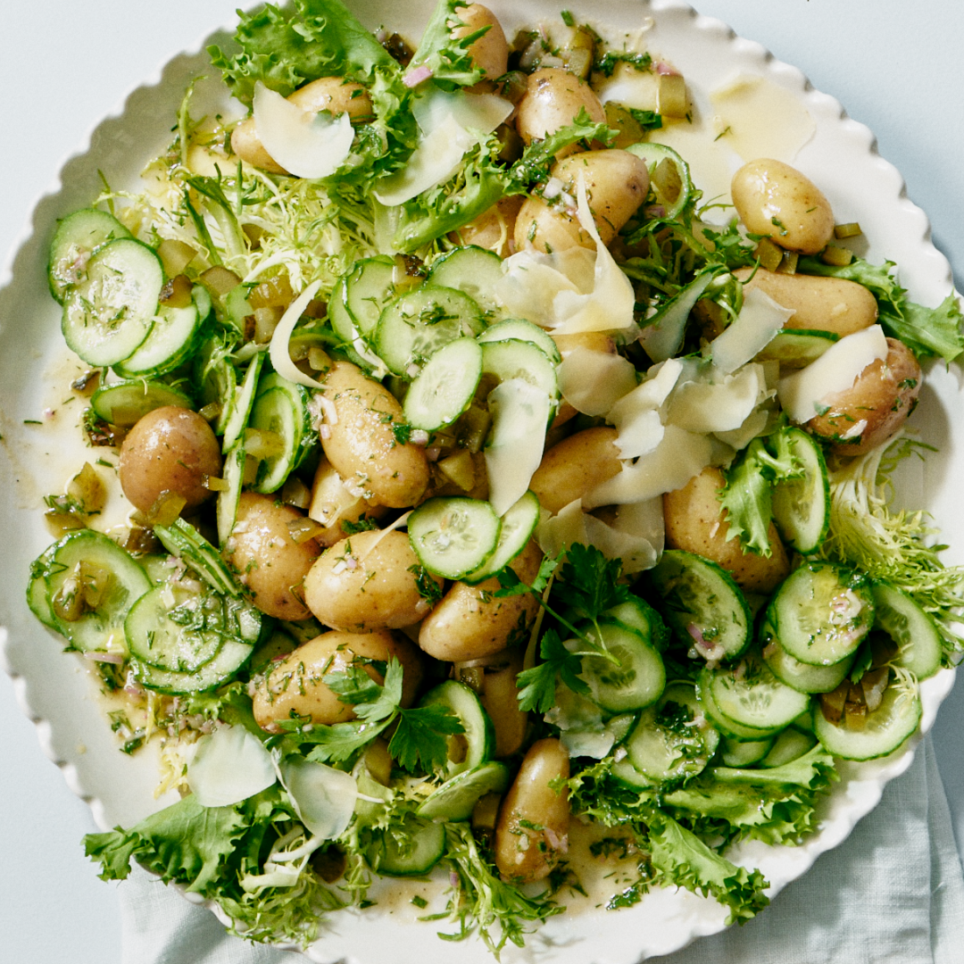 Bowl of potato cucumber salad with shaved Comté