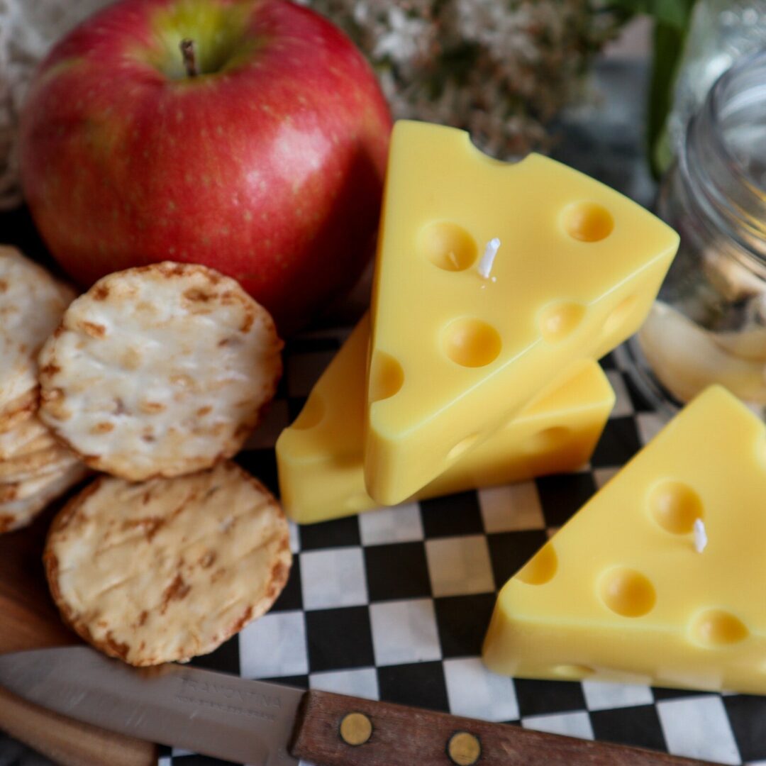 Swiss cheese shaped candle sitting on a cheeseboard