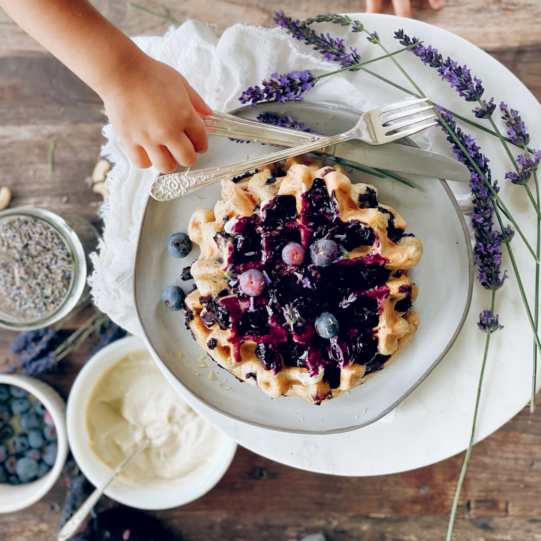 Recipe for waffles with lemon maple blueberry sauce shot overhead with fresh blueberries