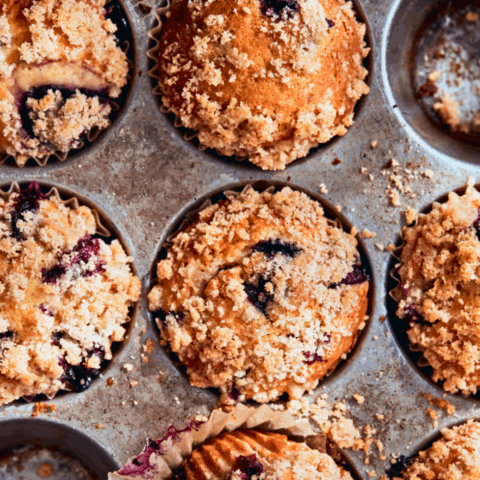 Close-up shot of a tray of blueberry crumb muffins.