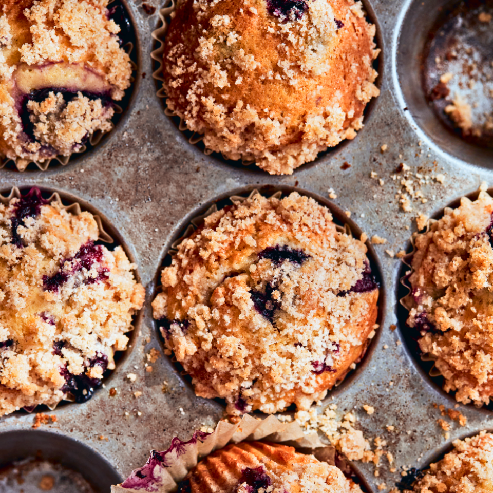 Close-up shot of a tray of blueberry crumb muffins.