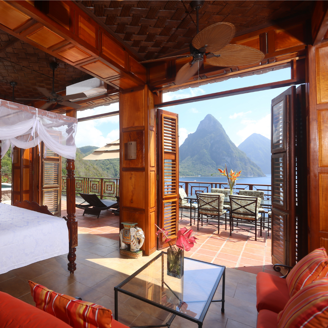 A spacious hotel suite in St. Lucia, overlooking a view of two jagged volcanic mountains.