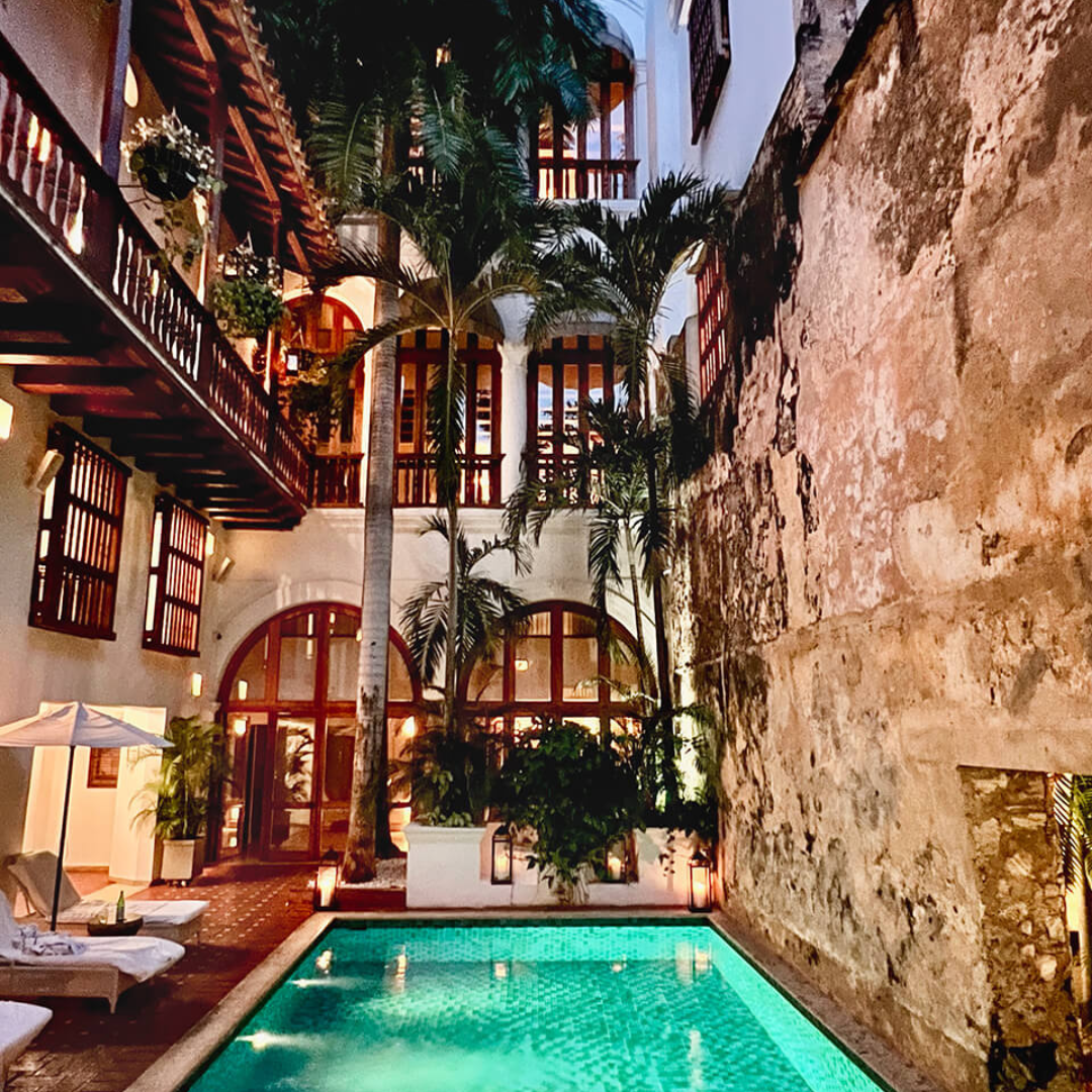 Room balconies at the Hotel Casa San Agustín overlooking a turquoise outdoor pool.