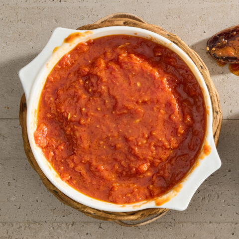 A white pot full of tomato sauce.