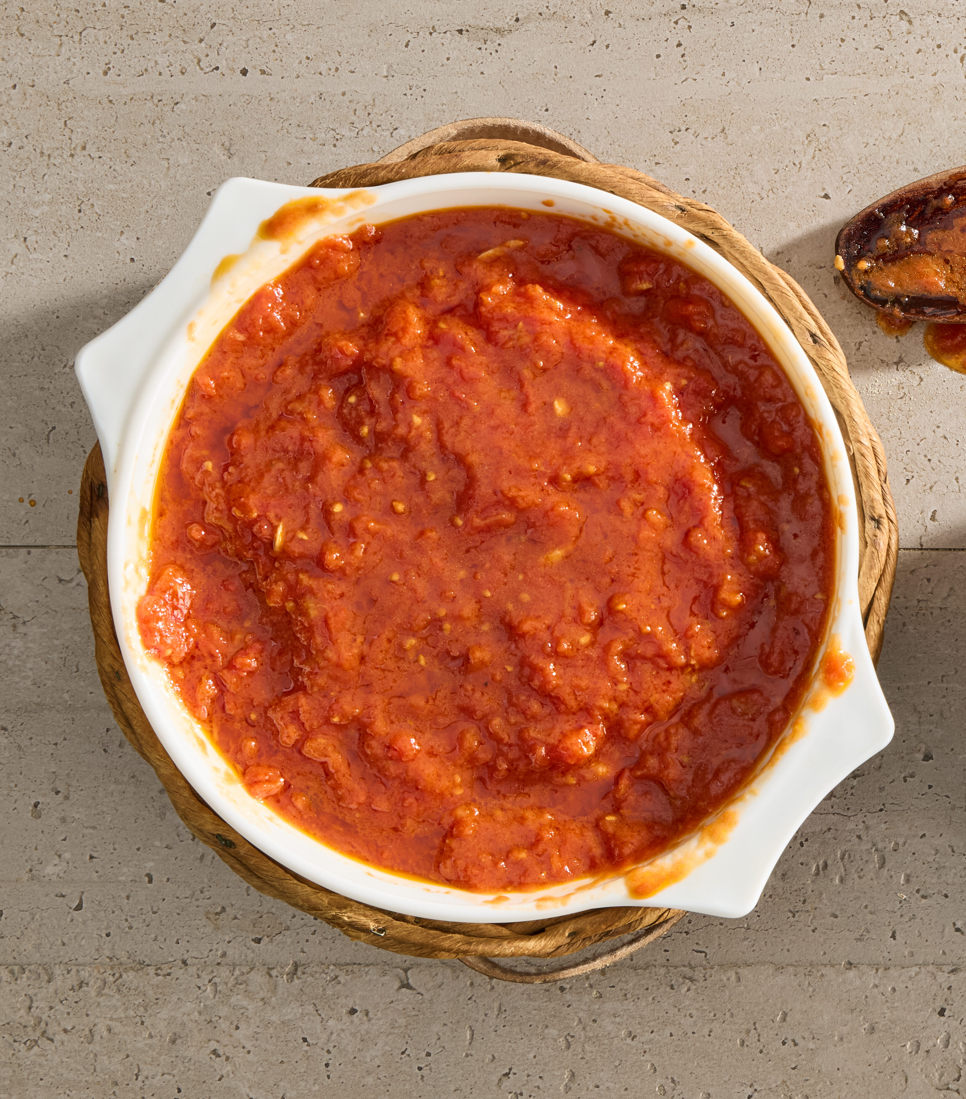 A white pot full of tomato sauce.