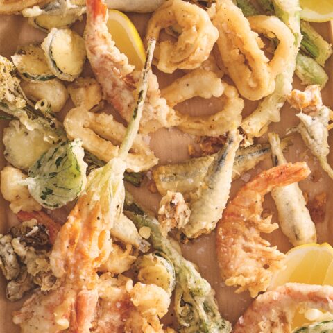 Parchment tray topped with assorted fried seafood.