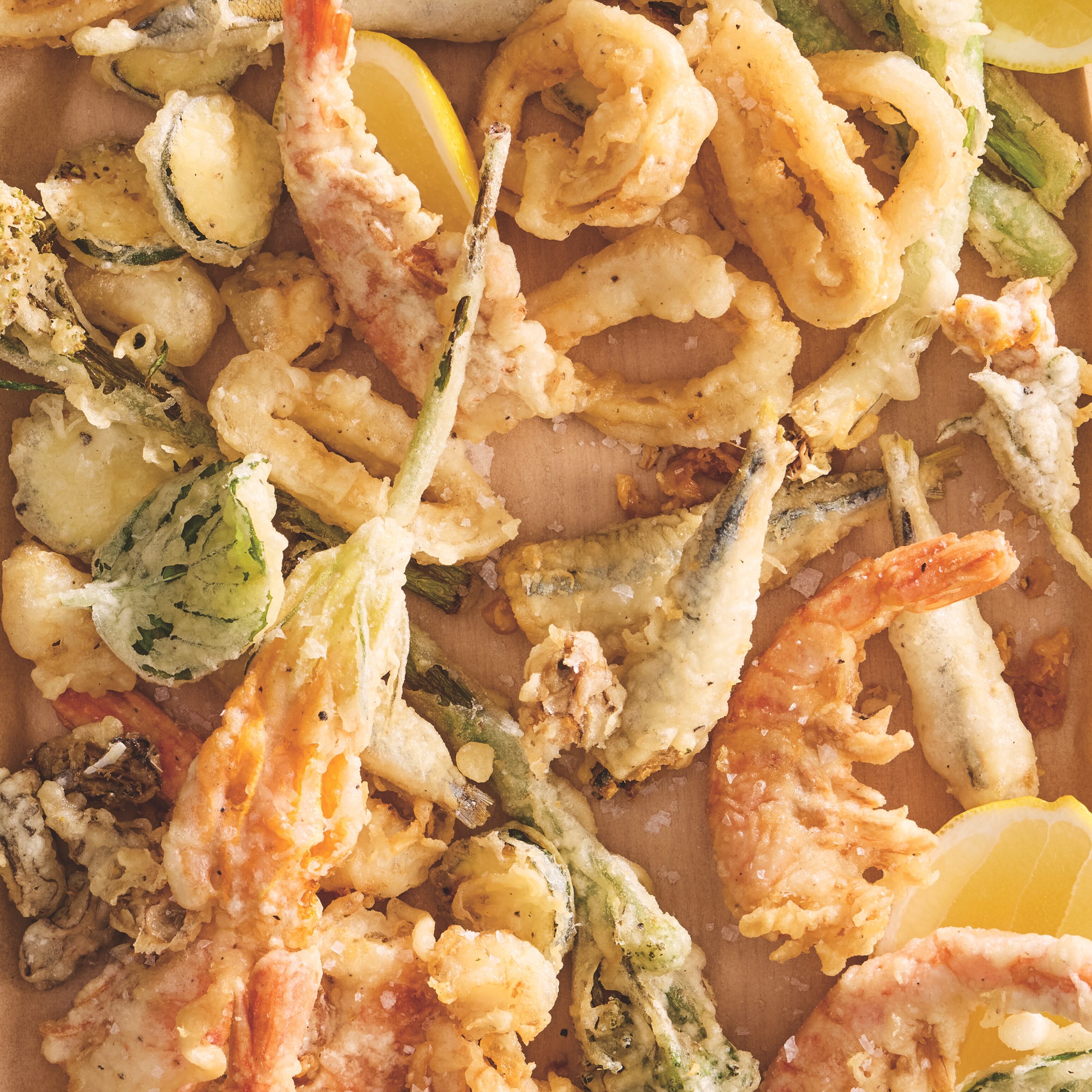 Parchment tray topped with assorted fried seafood.