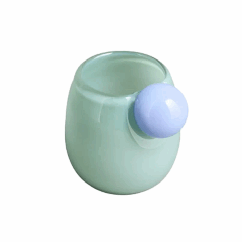 A turquoise glass espresso cup with a blue glass ball attached as the handle.