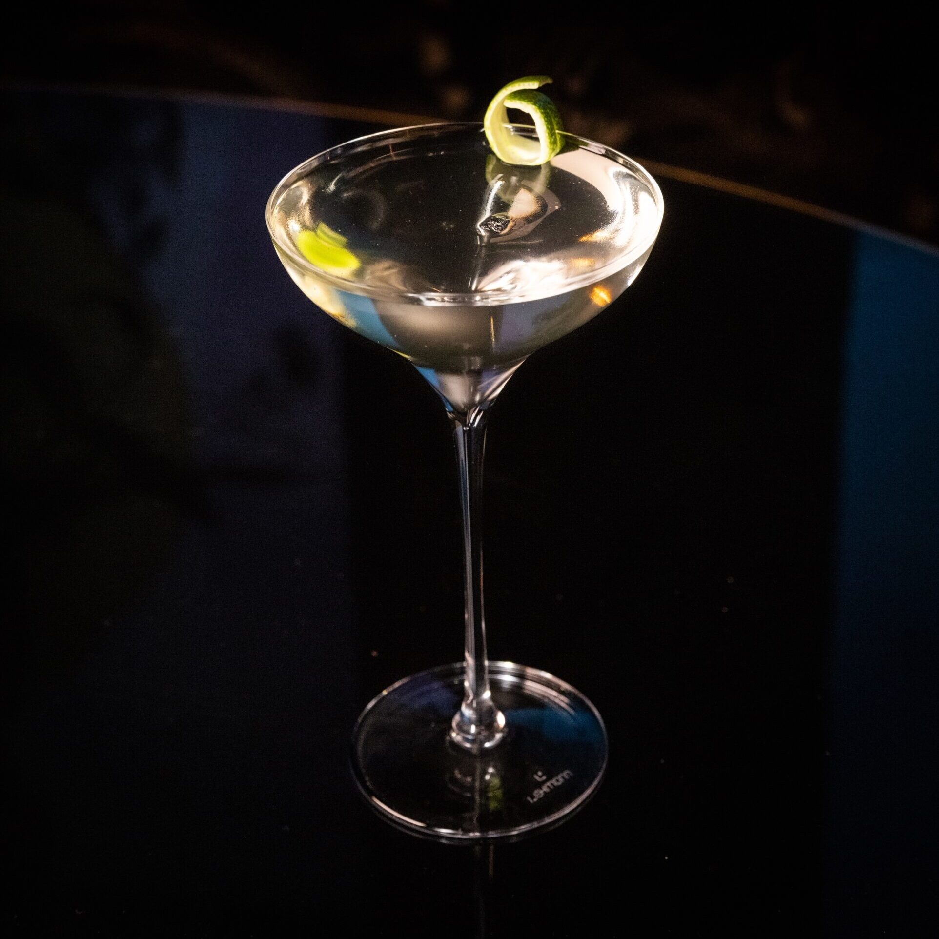 A full martini glass garnished with a lemon twist.