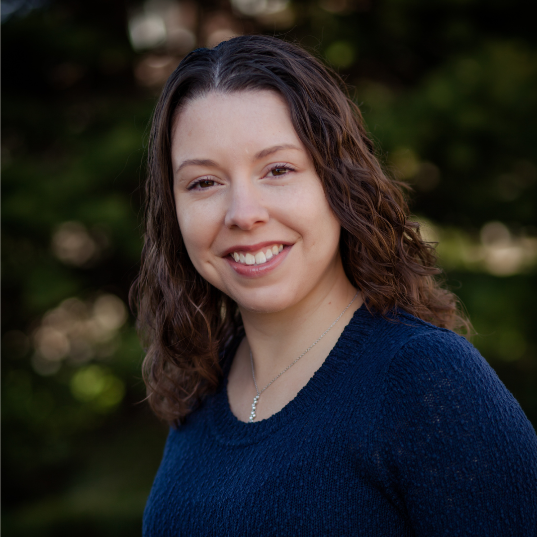 A headshot of a smiling woman wearing a blue shirt.