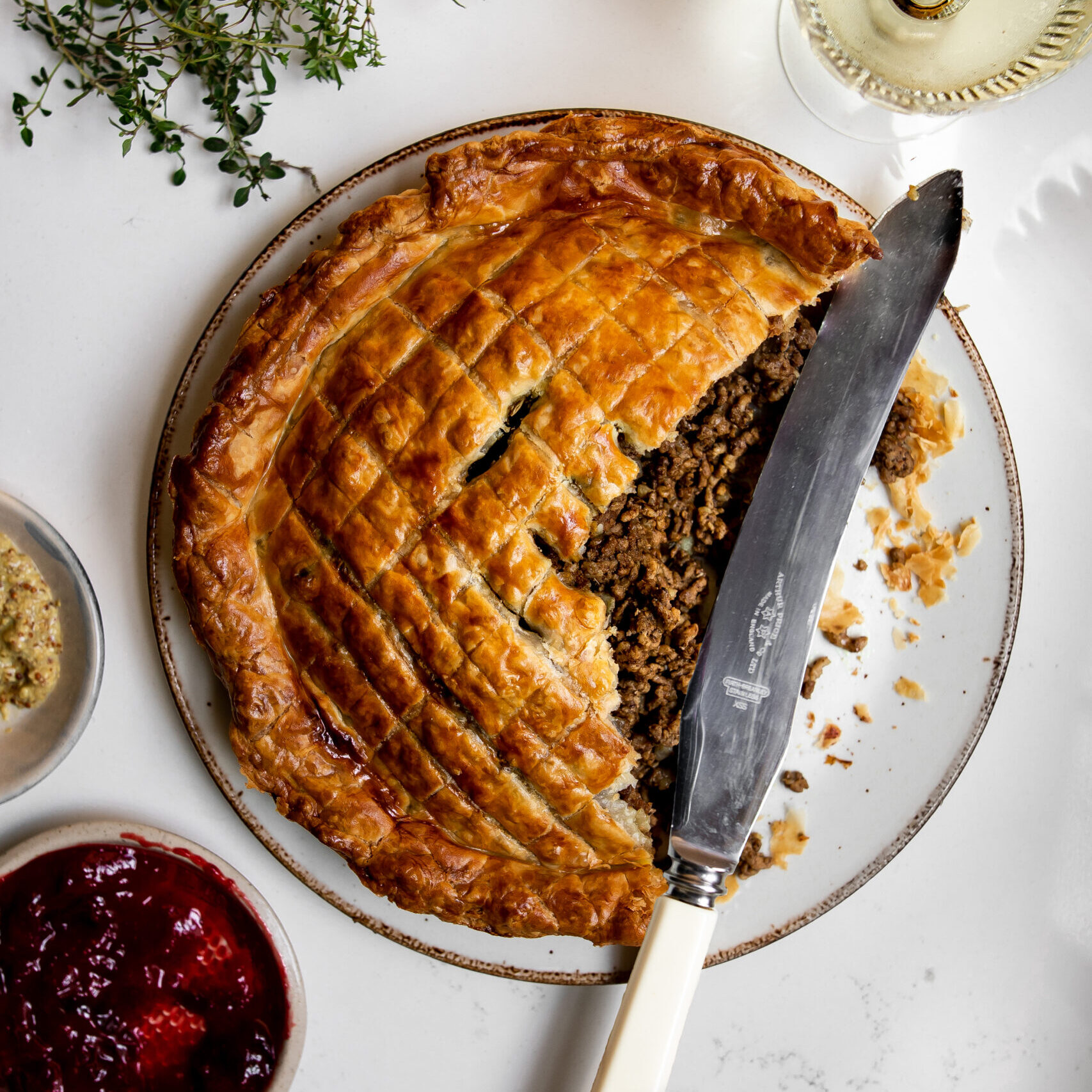 A large slice taken out of a Holiday Tourtiere with Puffed Pastry baked pie with meat filling showing.