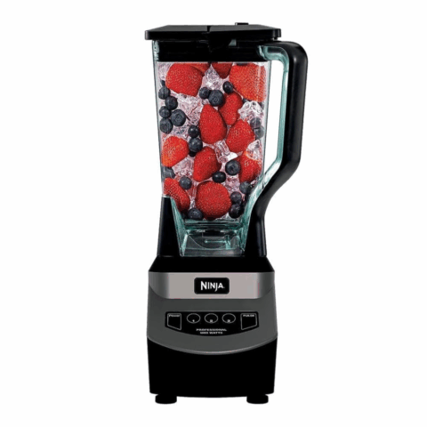 A black blender filled with ice cubes, blueberries and whole strawberries.