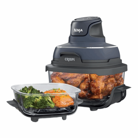 Clear air fryer with rotisserie chicken inside, next to a glass dish filled with salmon and broccoli.