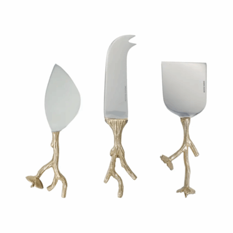 Three cheese knives with the gold handles that look like tree branches.