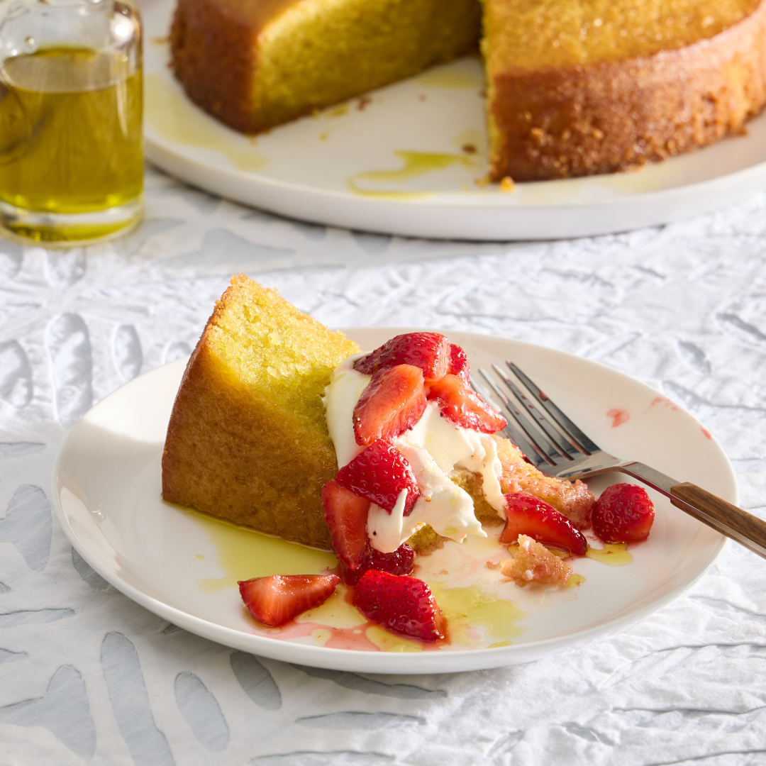 A slice of moist Olive Oil citrus cake with mascarpone cream and macerated strawberries