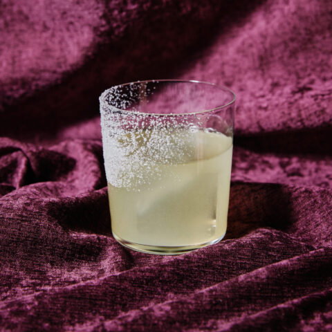A margarita with salt rim on a purple velvet background.