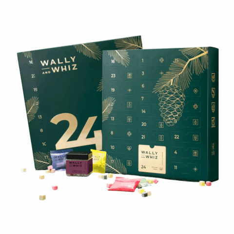 Two green advent calendars with four min bags and gummies strewn in front.