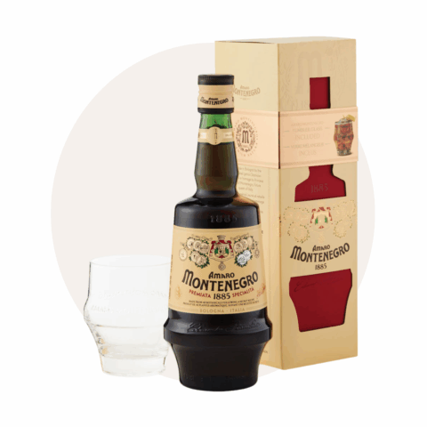 A bottle of Amaro Montenegro next to a clear glass and brown packaging.
