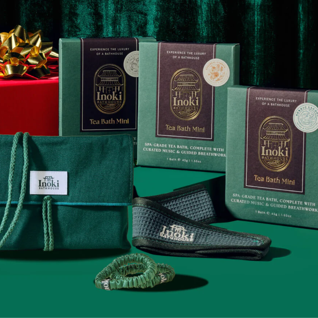 Three packages of tea soak, a green fabric bag, sweat band, and two hairties on a green background.