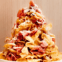 Layers of crispy kettle-cooked potato chips are stacked with torn prosciutto, drizzled with hot honey, and finished with a shower of freshly grated Parmesan.