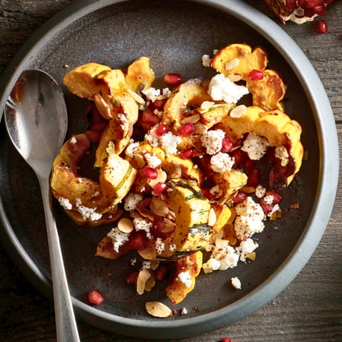 Roasted Delicata Squash Salad from Chef David Hawksworth is in a beautiful black dish and has feta and sprinkling of pomegranate seeds