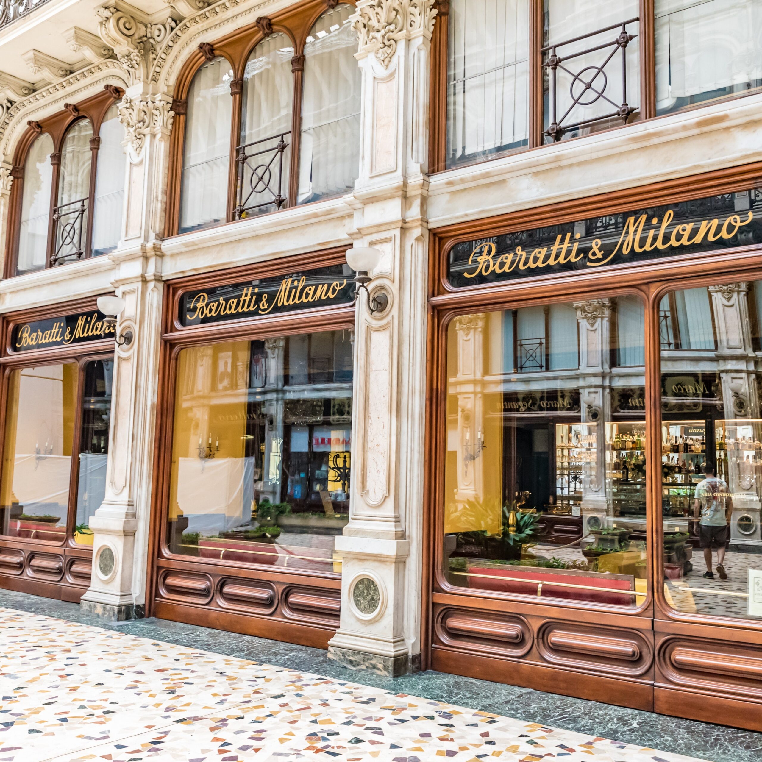 White-stone cafe façade with tall pillars and large windows — historic confectionery house in Turin.