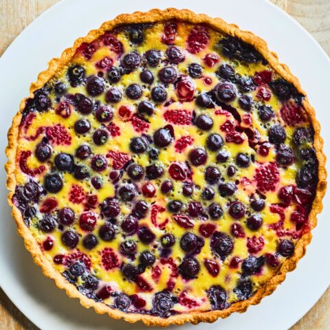 Cherry and berry clafoutis tart with sweet-tart cherries, blueberries and baked vanilla custard in a buttery pastry shell.
