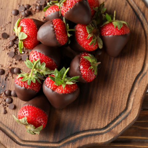 Chocolate-covered strawberries with dark chocolate on a wooden board